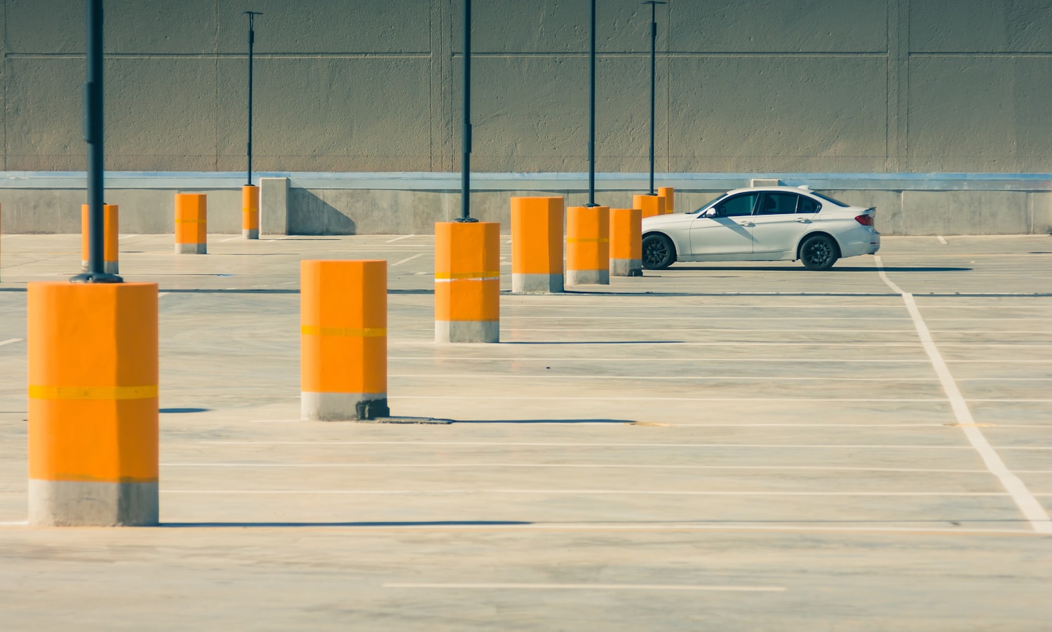 Sunlit asphalt parking lot with clean painted lines in bright daylight
